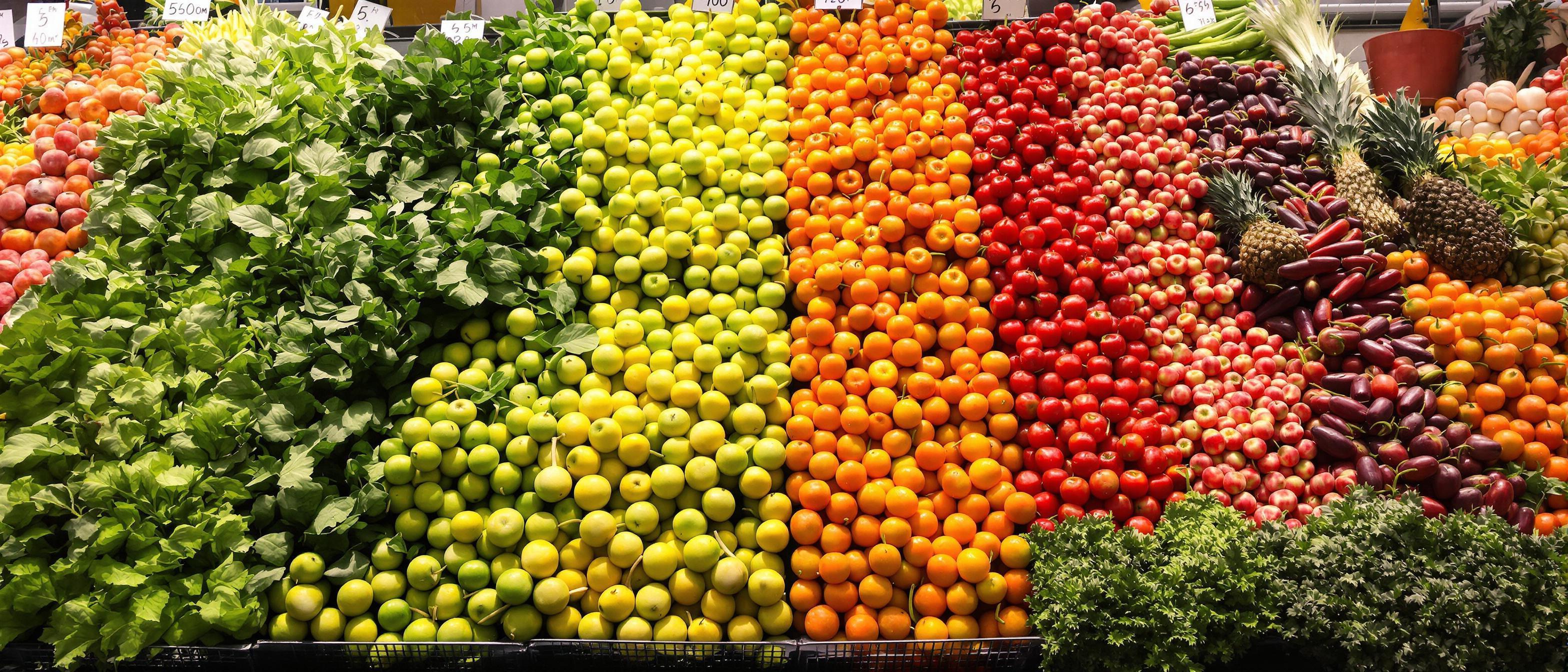 A vibrant arrangement of fruits and vegetables organized by color, showcasing a spectrum from green to red.